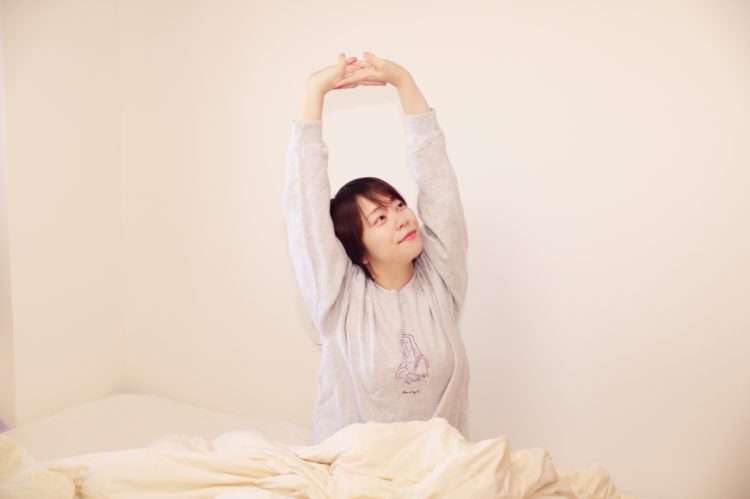 ざらざら肌対策のためしっかり睡眠をとり、すっきり目覚める女性